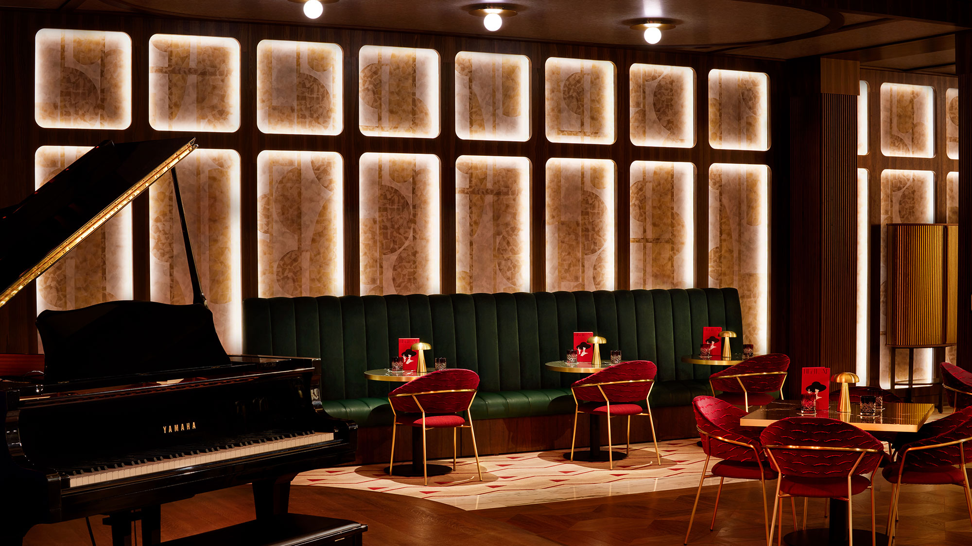 A piano in a room with tables and chairs.