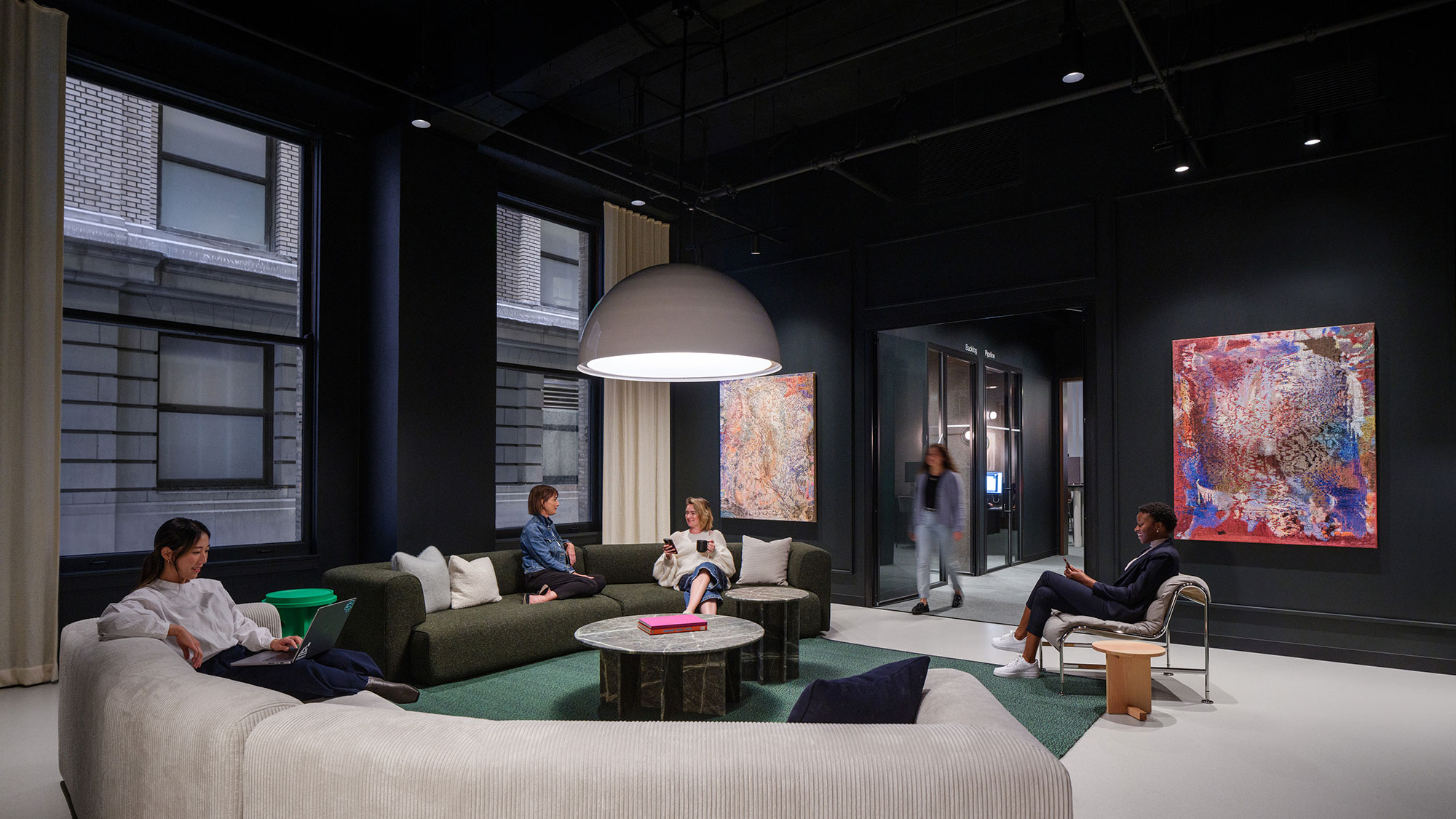 A group of people sitting on a couch in a room with a large screen.