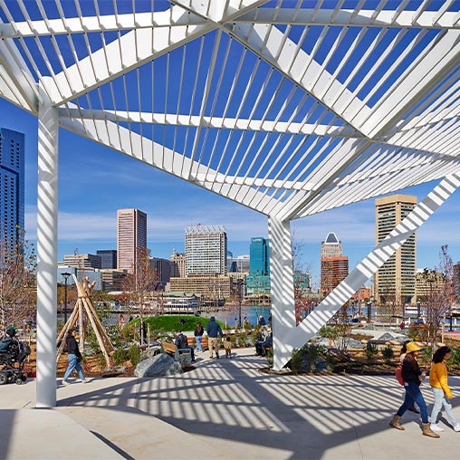 A group of people walking on a bridge over a body of water.