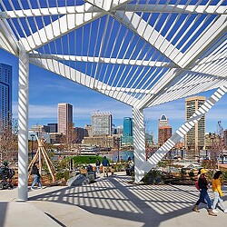 A group of people walking on a bridge over a body of water.