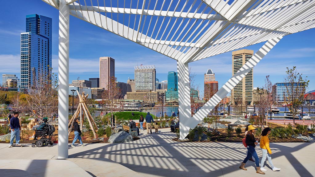 A group of people walking under a bridge.