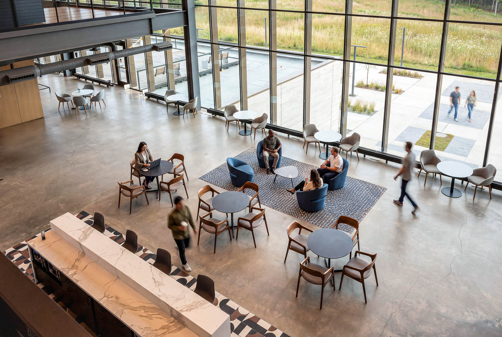 A group of people sitting around a table with chairs around it.