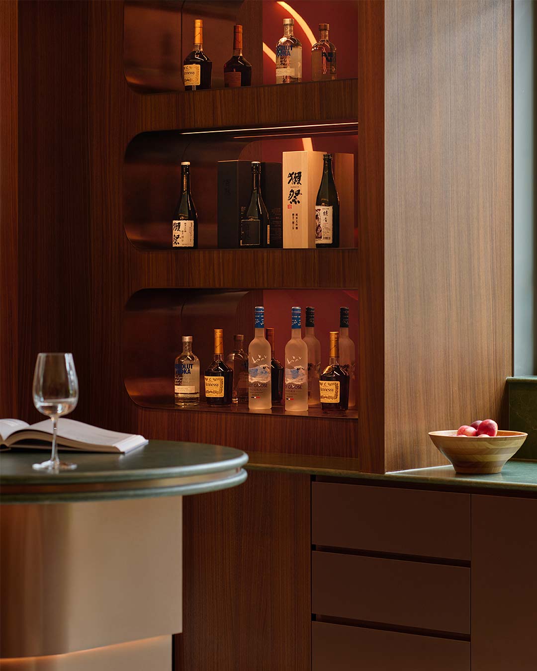 A shelf with bottles and glasses on it.
