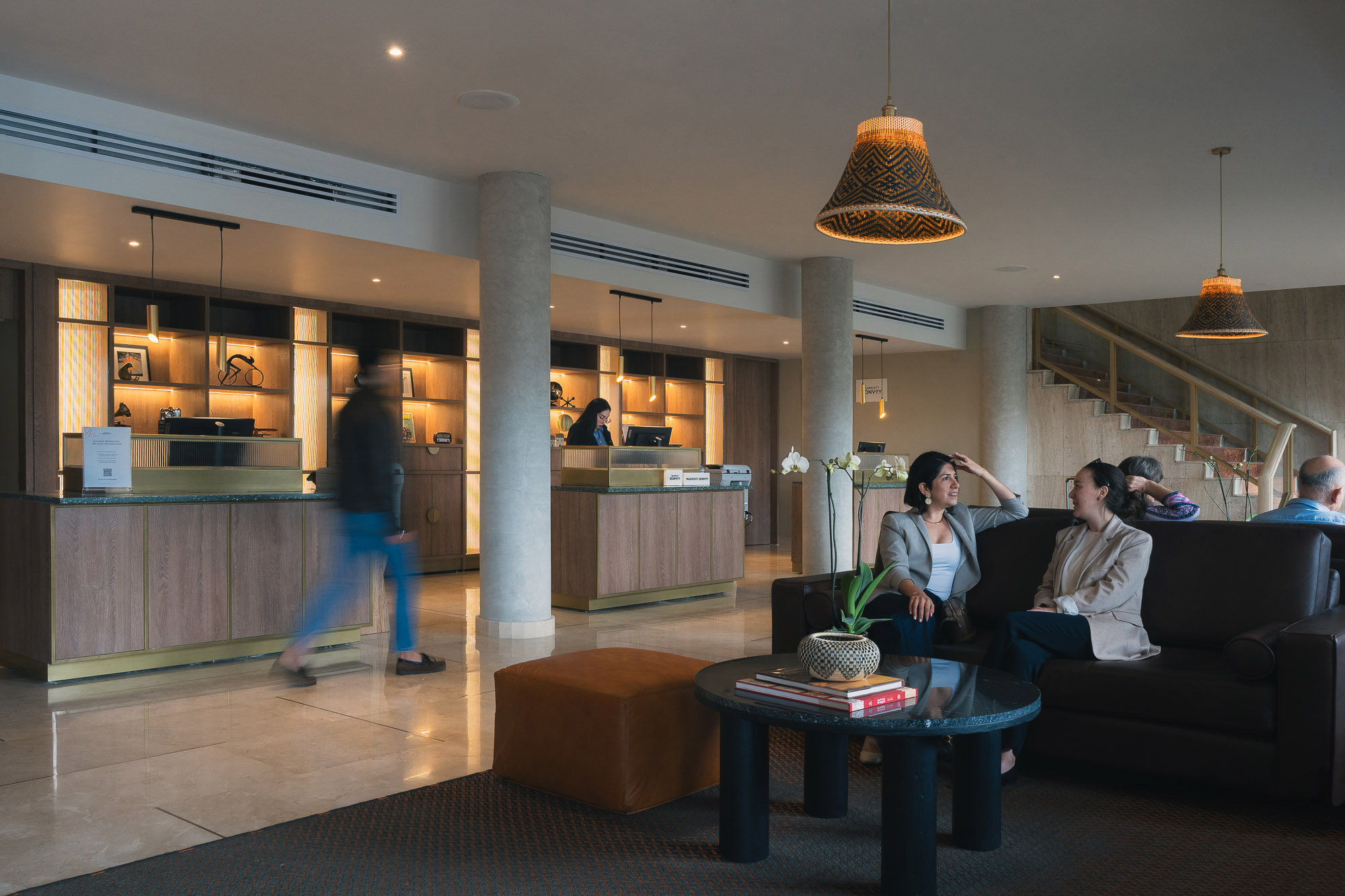 A group of people sitting on a couch in a large room.