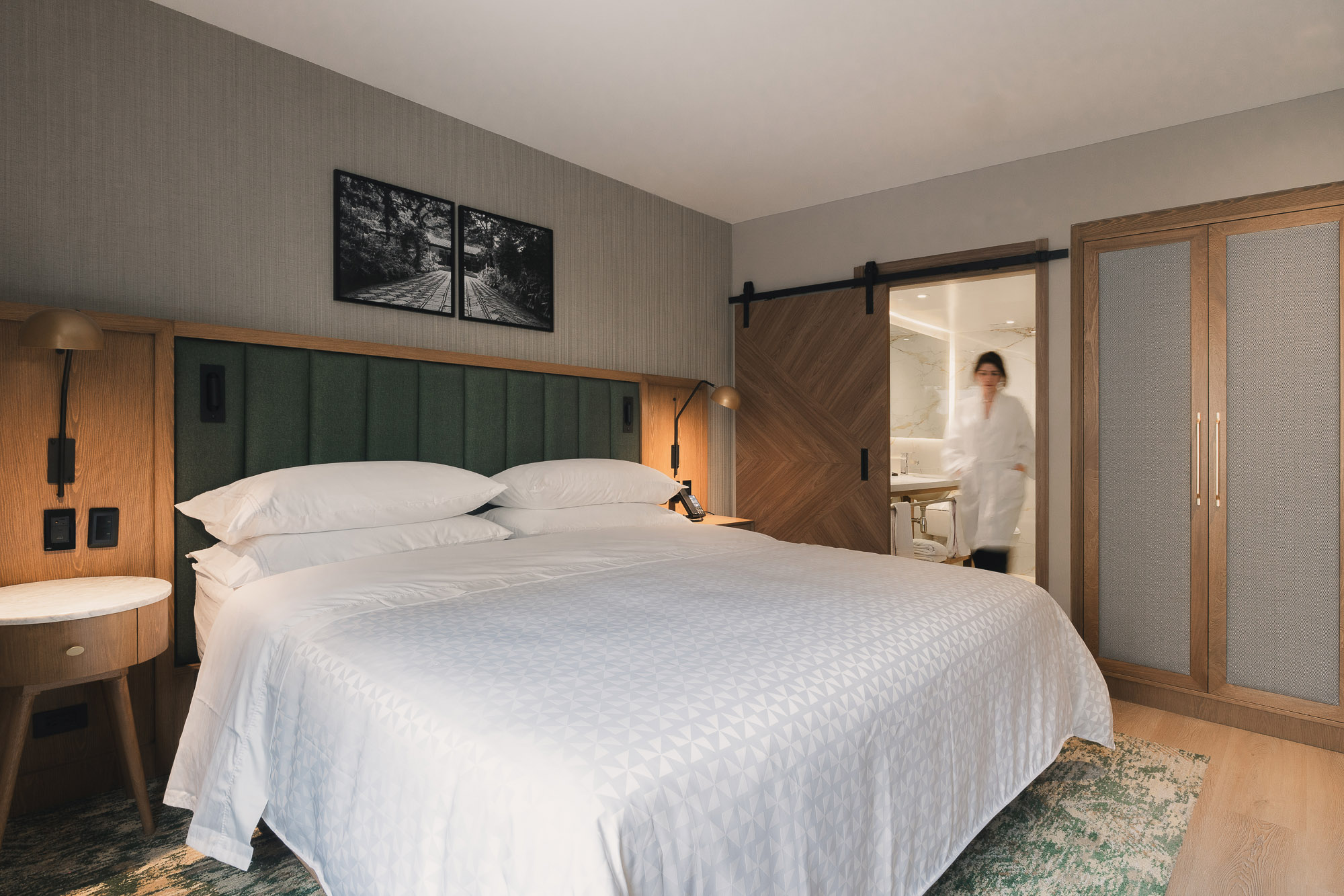 A person standing in a bedroom.