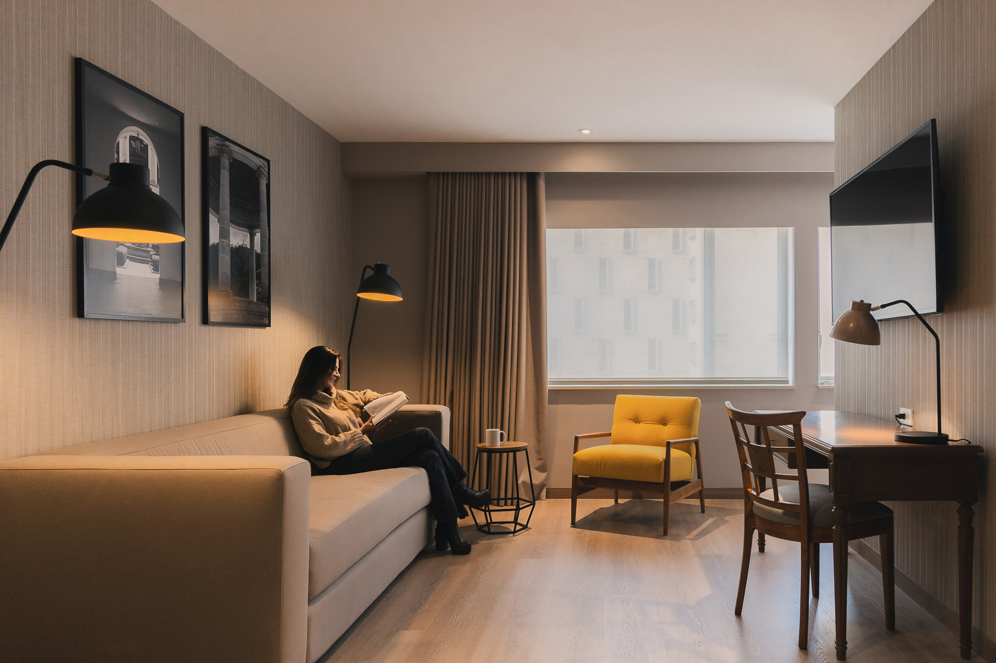 A person sitting on a couch reading a book.