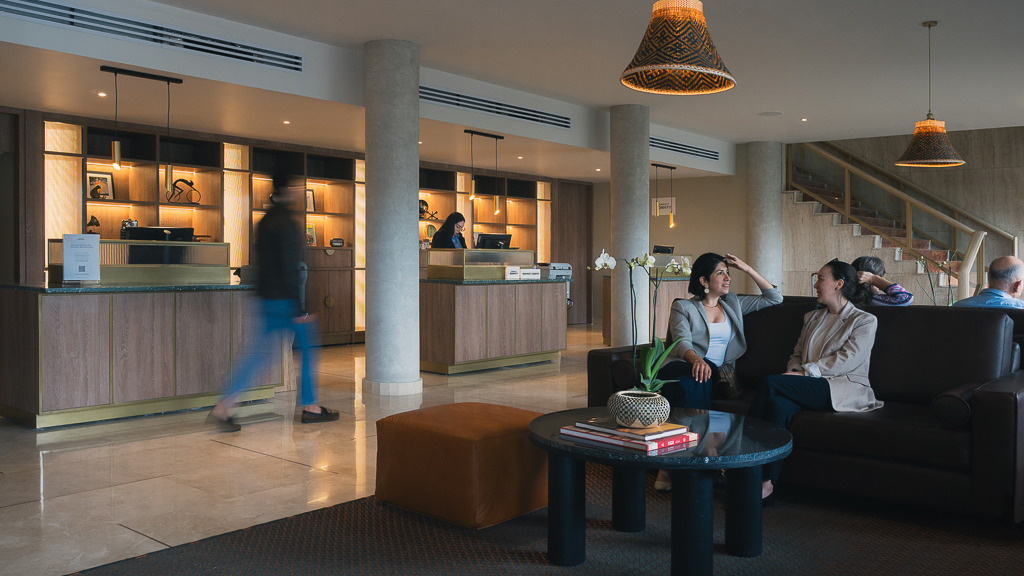 A group of people sitting on a couch in a large room.