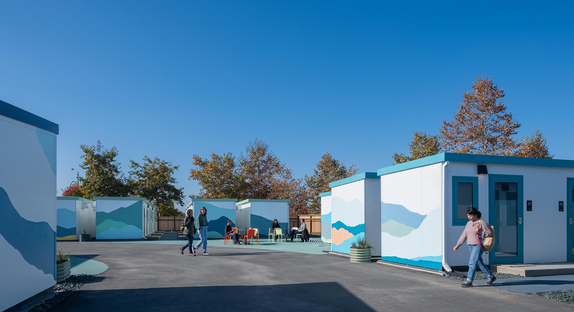 People walking near blue buildings.