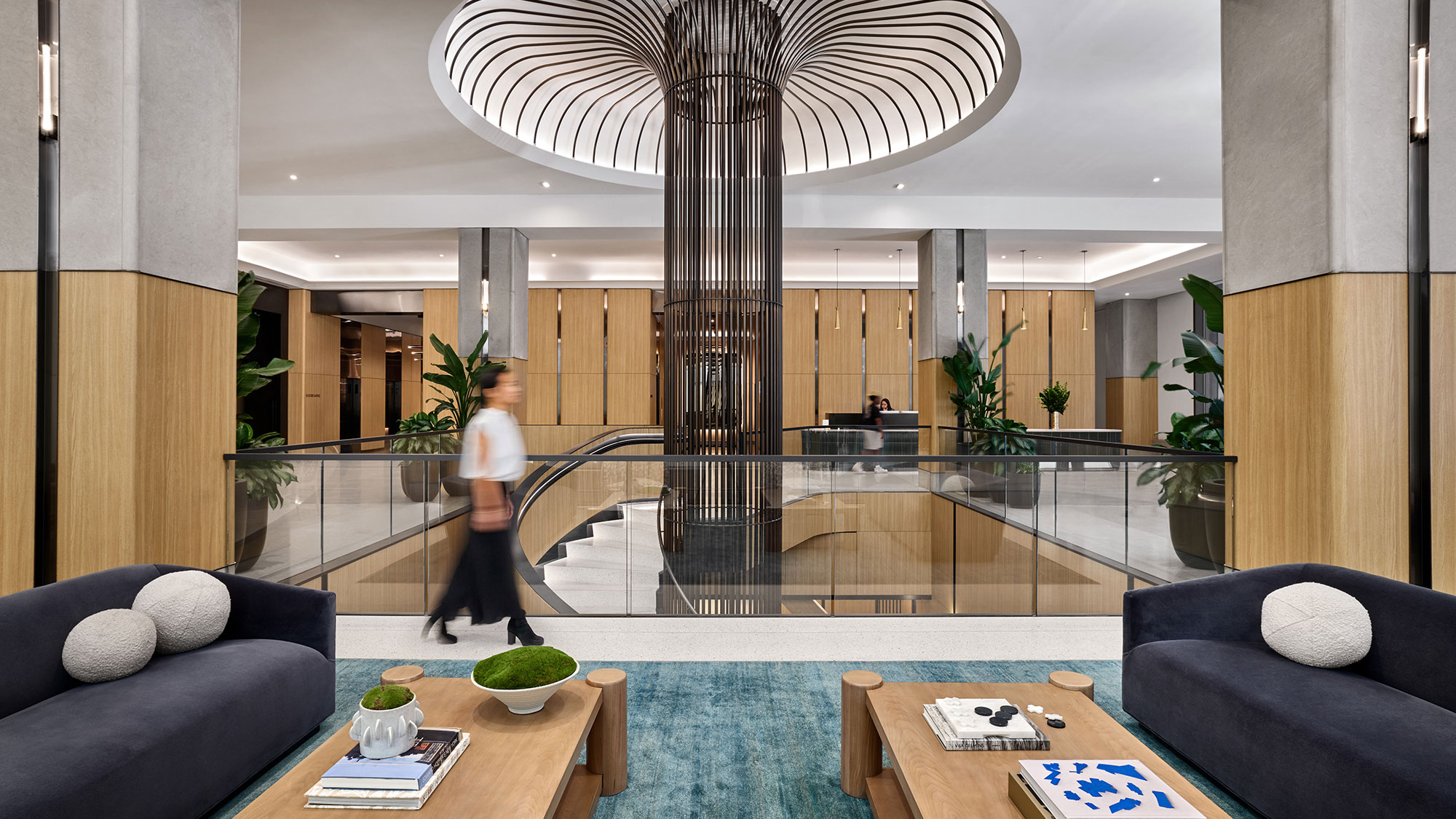A room with a glass wall and a couple people walking by.