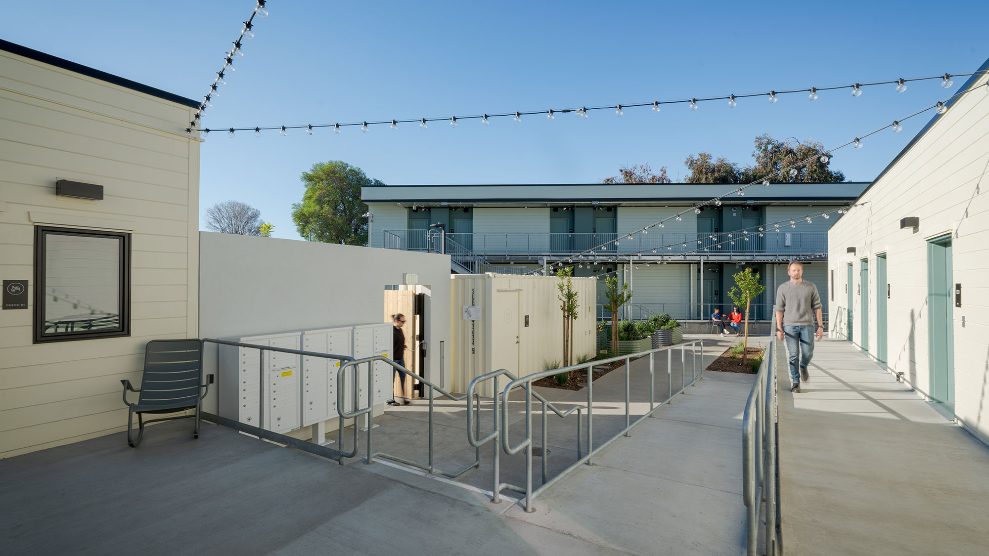 A person walking on a walkway between buildings.