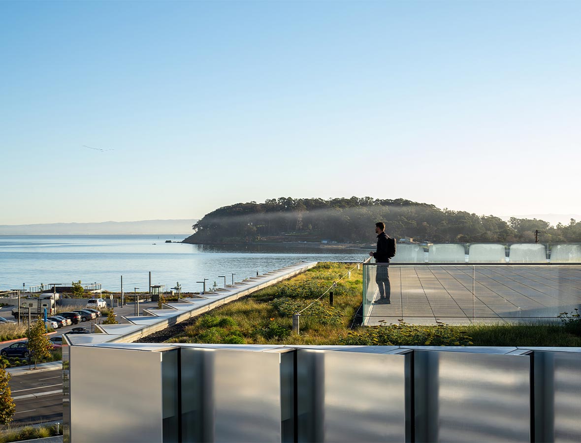 A person standing on a bridge over a body of water.