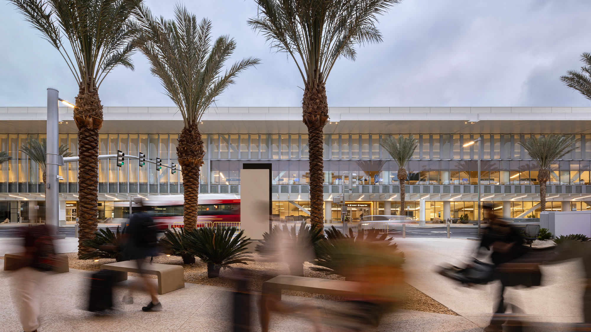 A building with palm trees and a fountain in front of it.