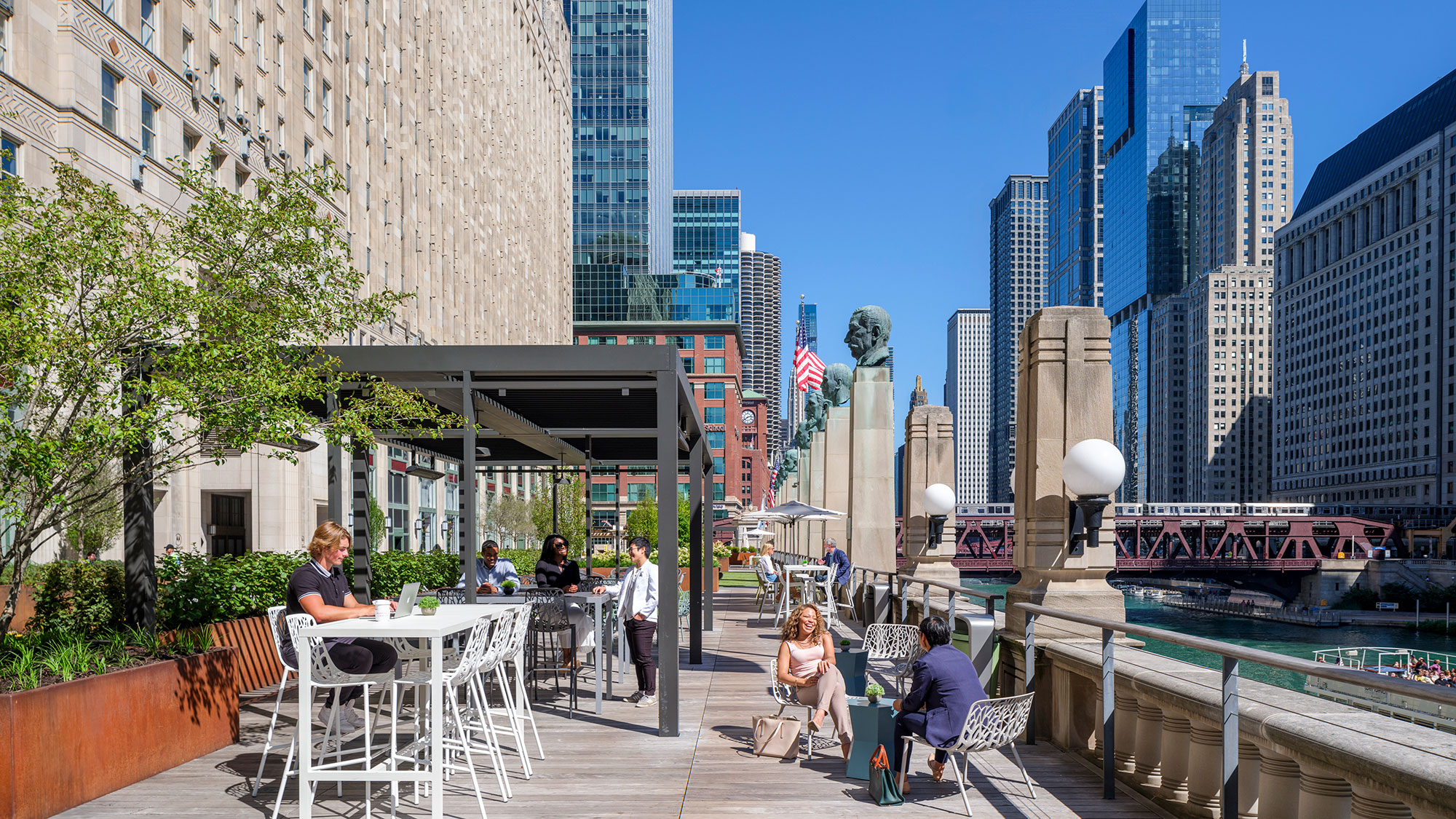 A group of people sitting at tables in a city.
