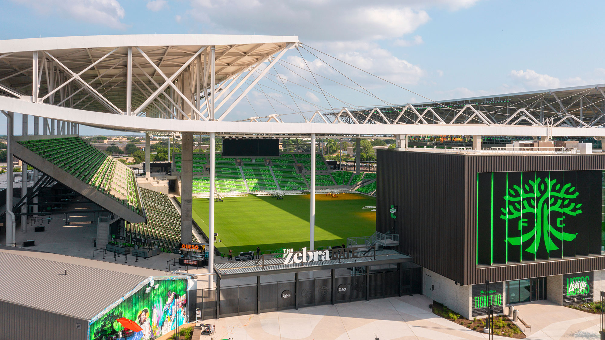 A sports stadium with a green field.