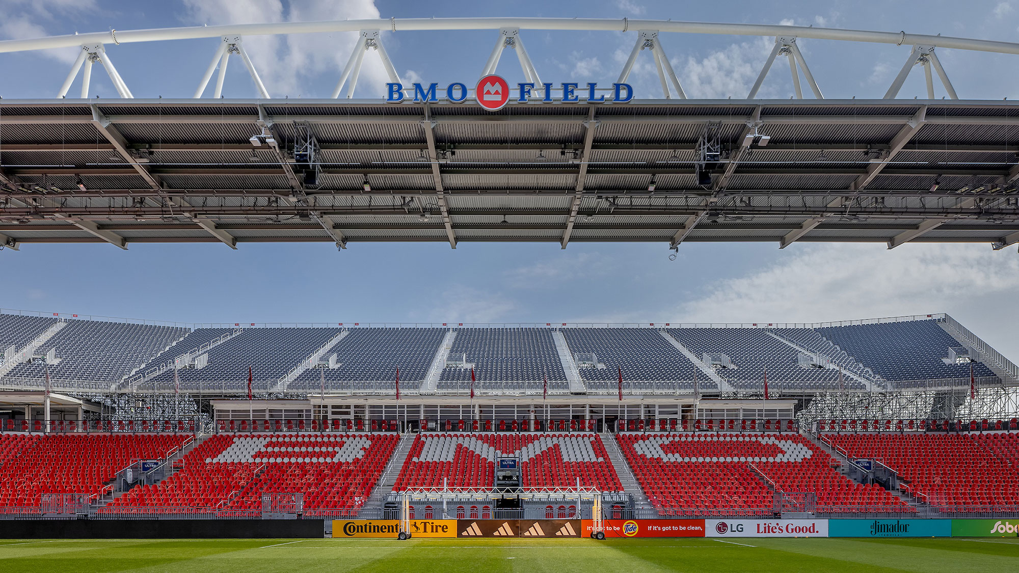 A large stadium with a field and a large crowd.
