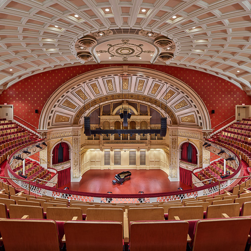 A large theater with red seats.