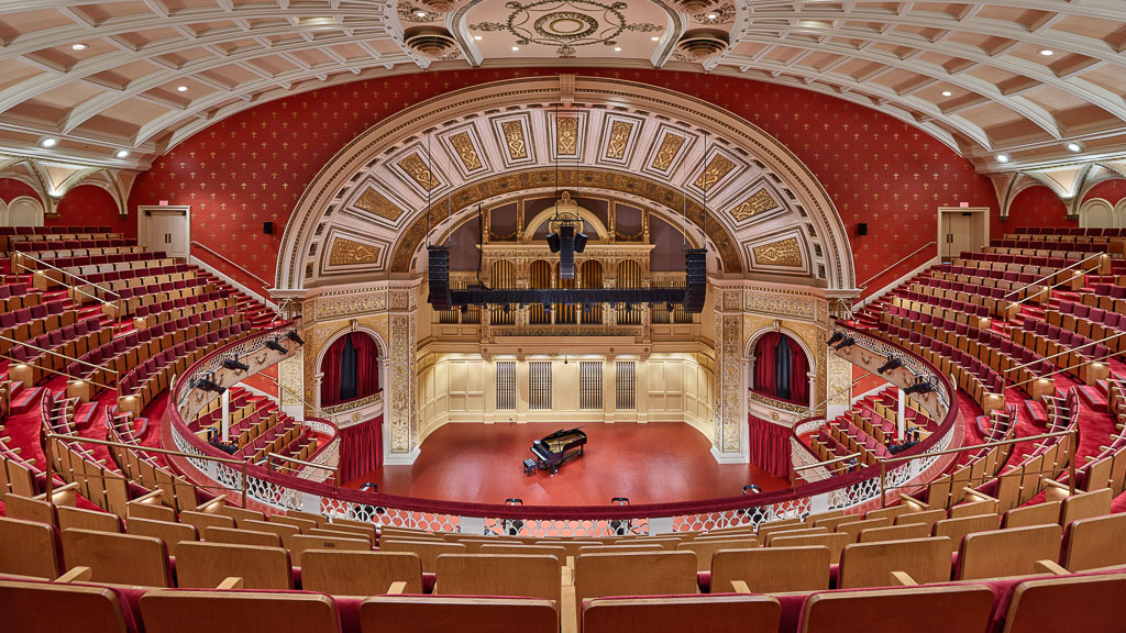 A large theater with red seats.