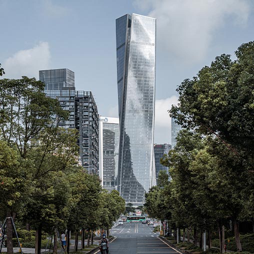 A road with trees and tall buildings.