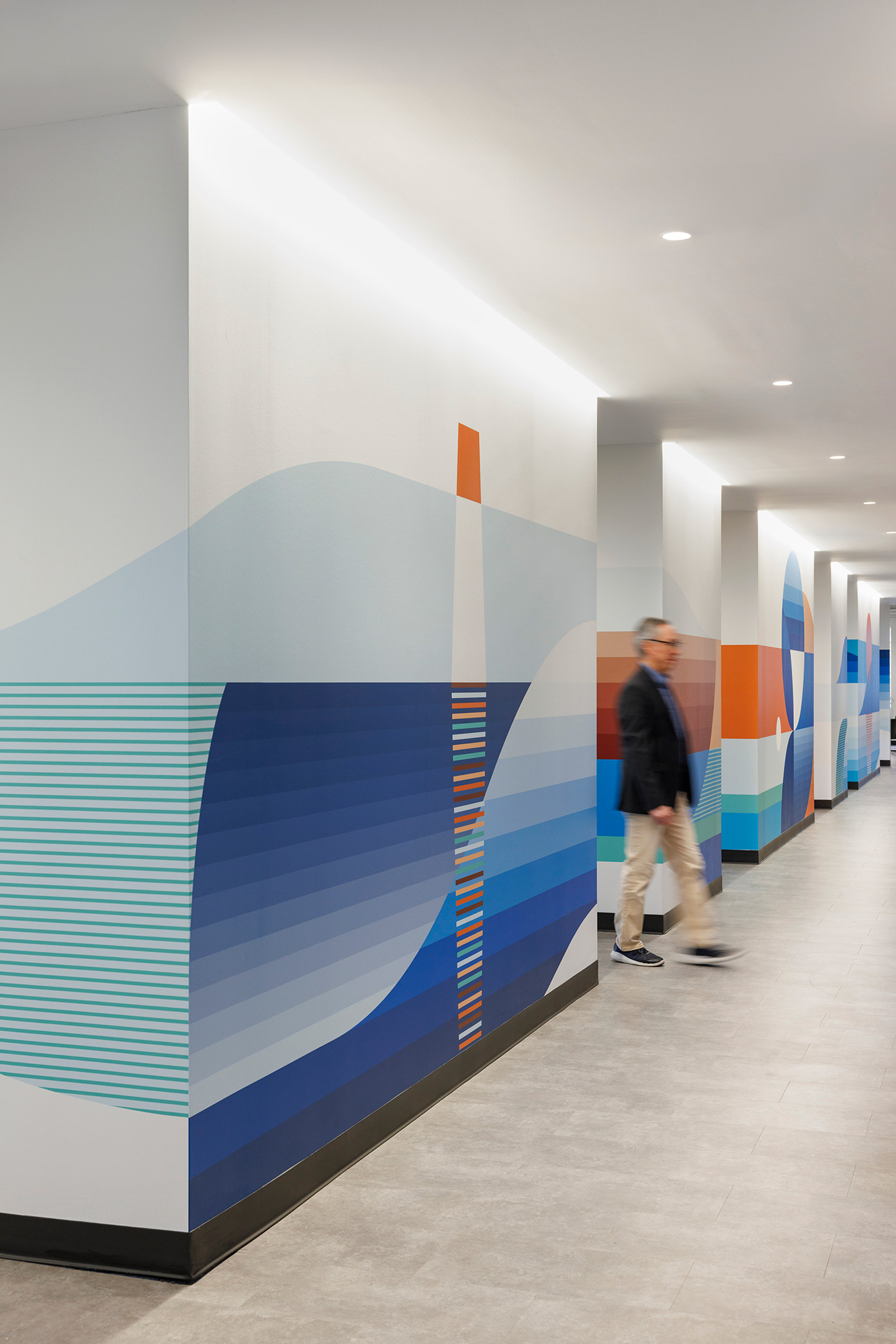 A person standing next to a wall with a design on it.