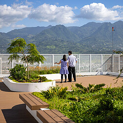 A man and woman standing on a balcony overlooking a body of water.