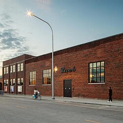 A brick building with a person walking by it.