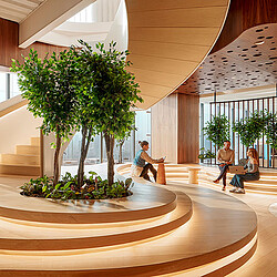 A group of people sitting on a bench in a building.