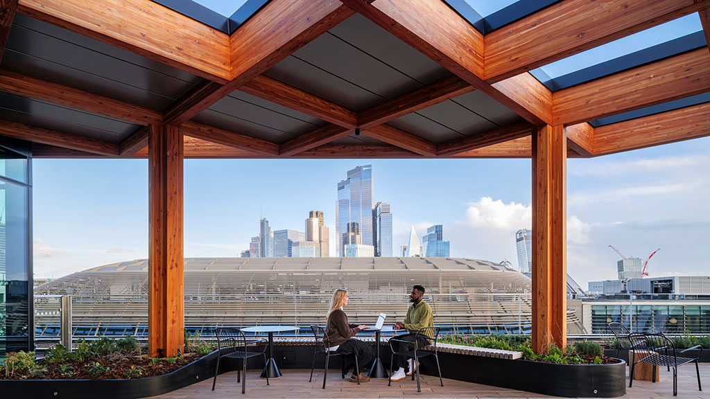 A man and woman sitting at a table with a view of a city.
