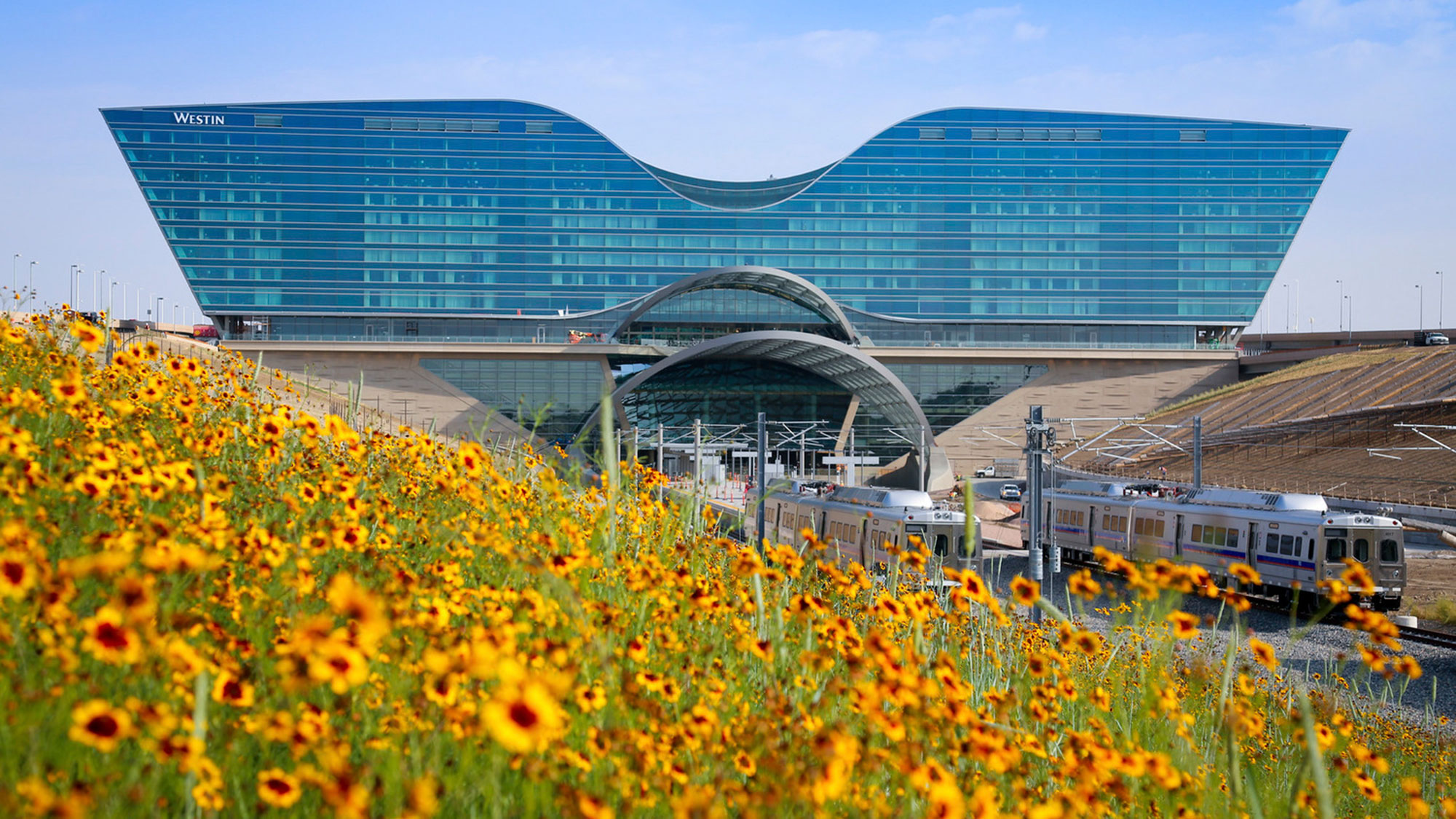 A train going by a large building.
