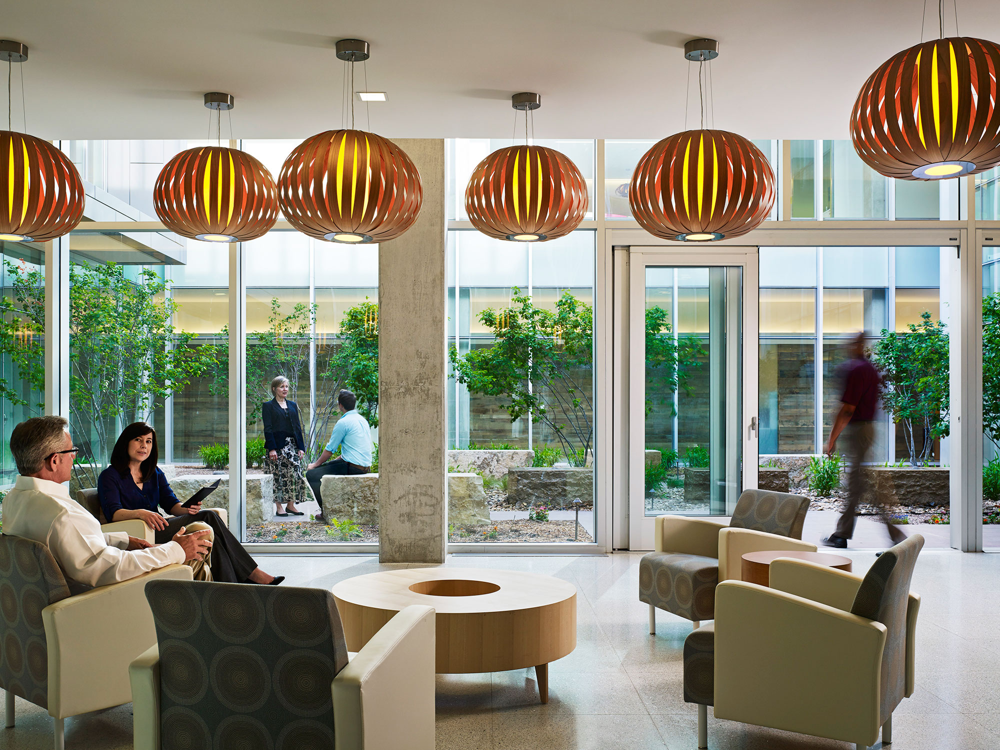 A group of people sitting in a room with large pumpkins from the ceiling.