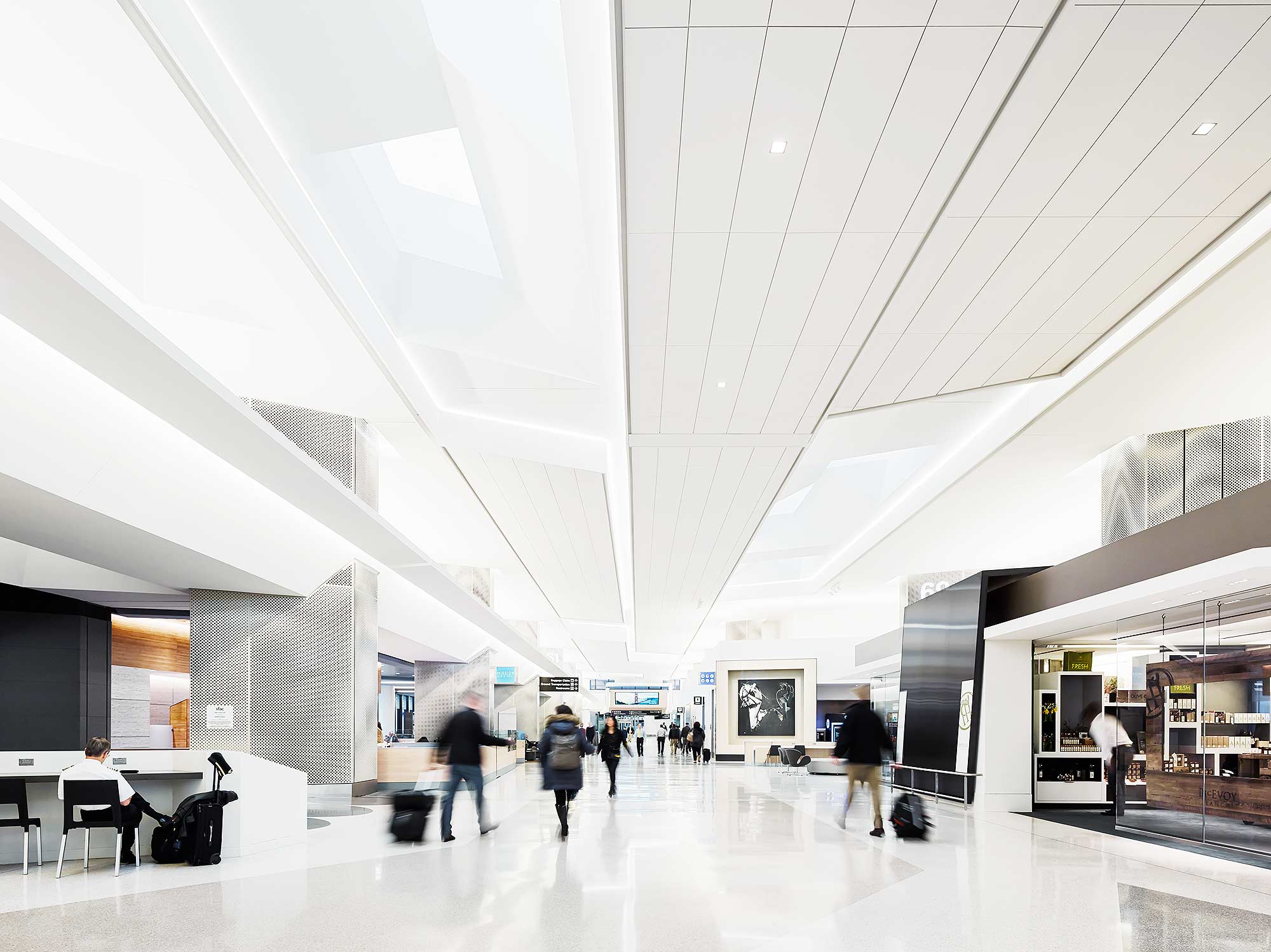 A large white room with people and a large white ceiling.