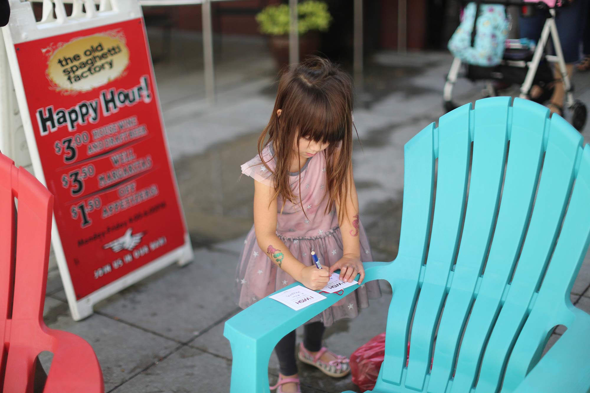 A little girl sitting on a bench.