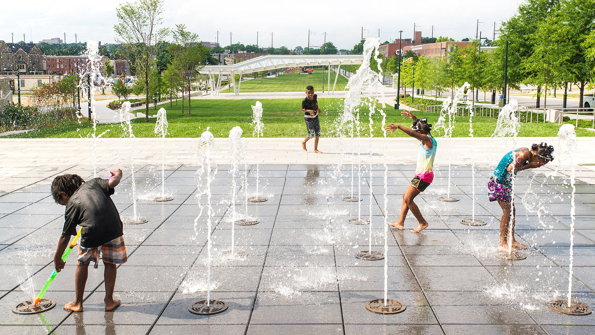 A group of people playing in a water fountain.