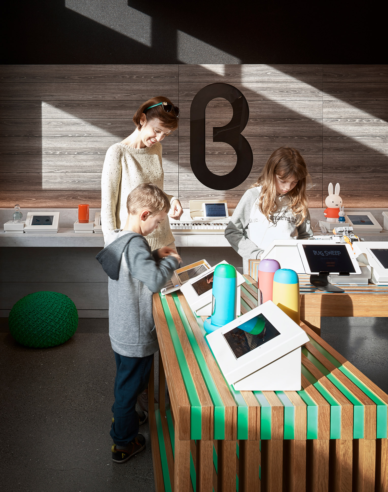 A group of people standing around a table with a laptop and a sign.