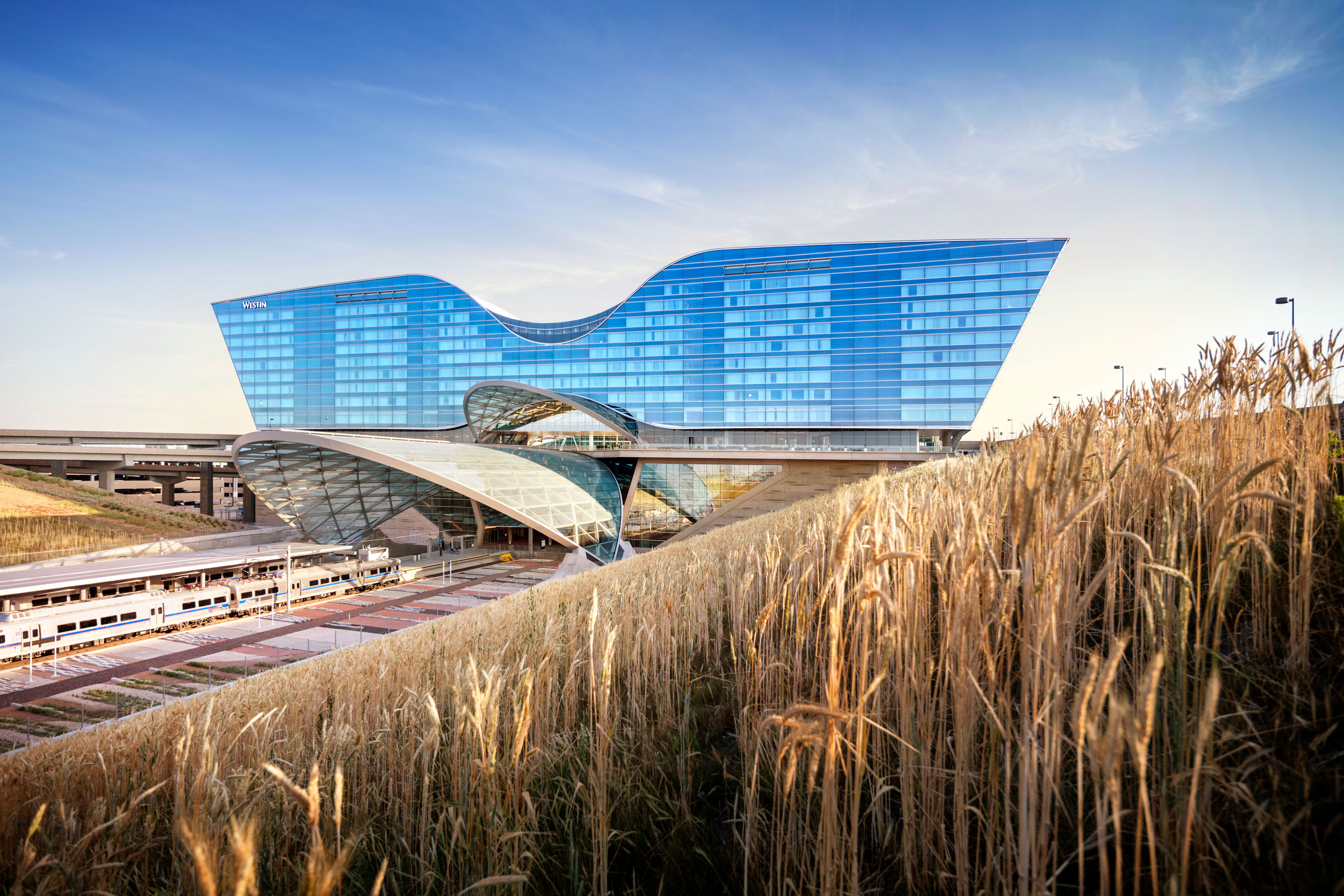 A train going by a large building.