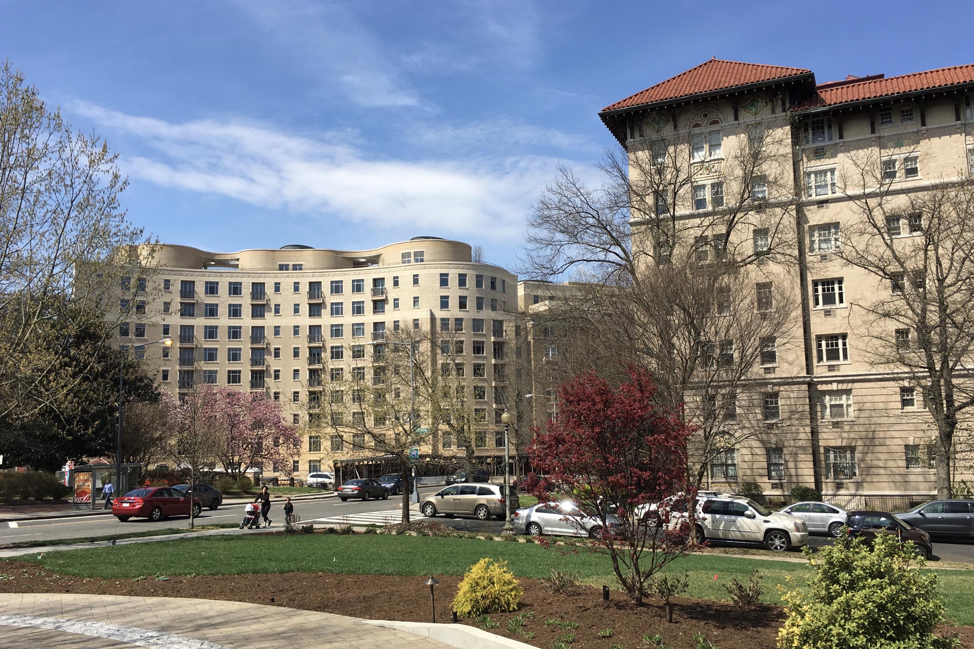 A group of buildings with cars parked in front of them.