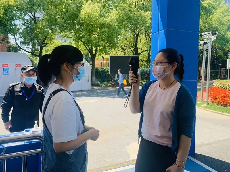 A person taking a picture of another woman with a mask on.