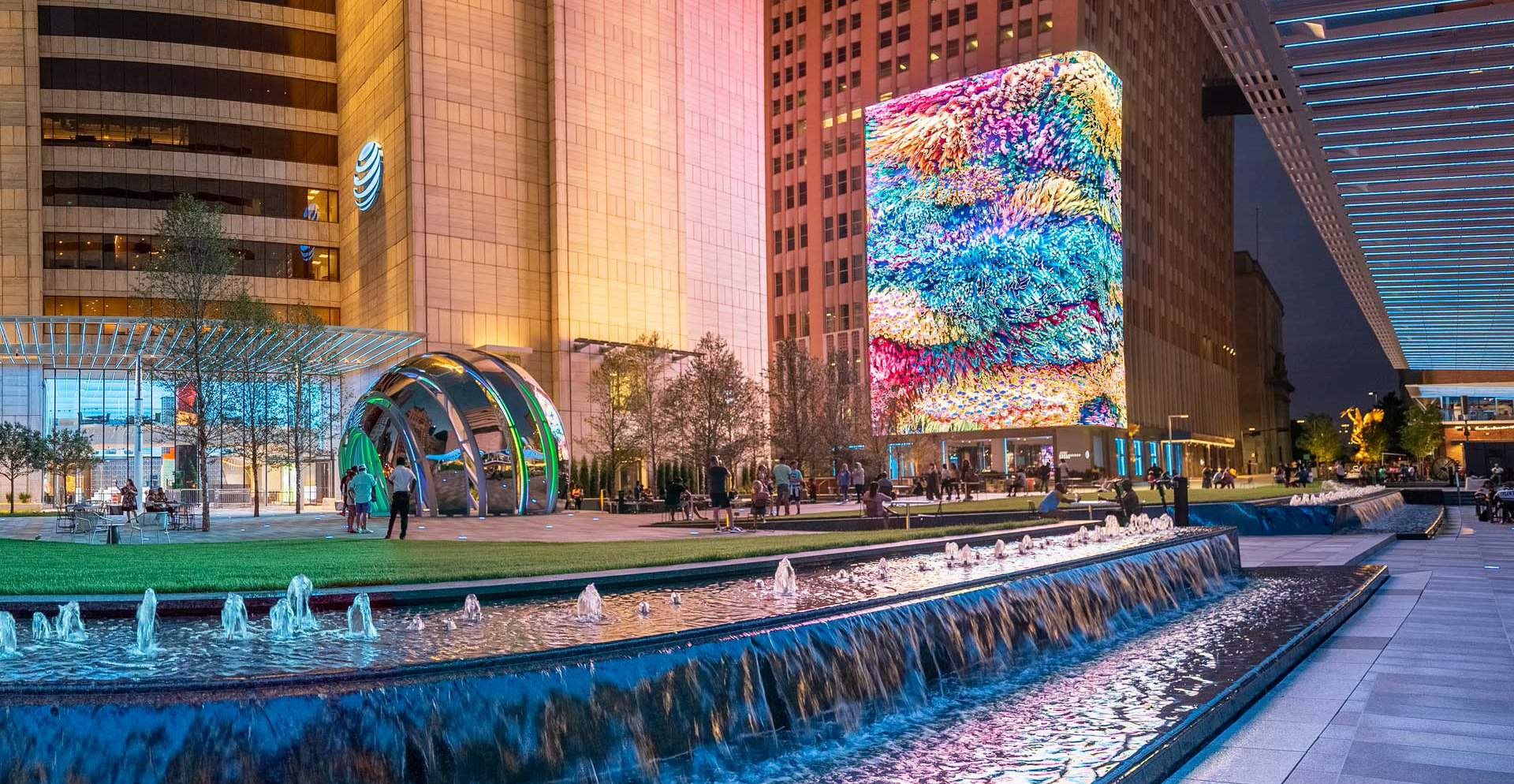 A large building with a large colorful glass fountain in front of it.