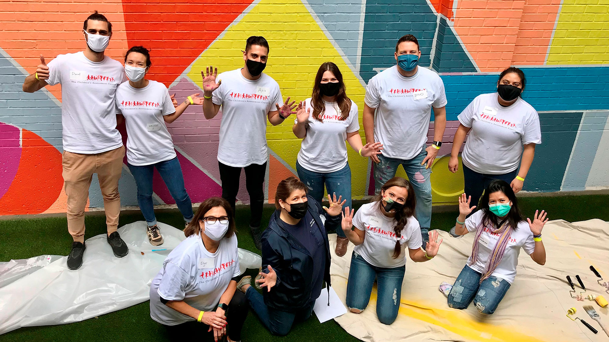 A group of volunteers paint a mural