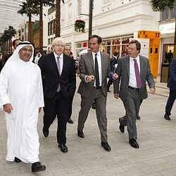 A group of men walking down a sidewalk.