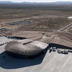 A large concrete structure with a road and cars in the background.