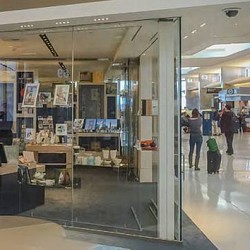 A glass front door with people walking around.