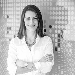 A woman smiling with her arms crossed.