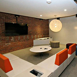 A room with a brick wall and a table with a tv on it.