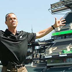 A man pointing at a stadium.