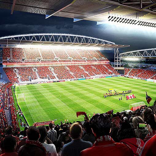 A football stadium with a field and people in the stands.