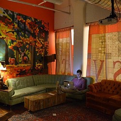 A person sitting on a couch with a laptop.