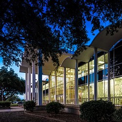 A building with columns and a tree.