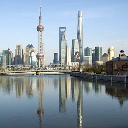 A city skyline with a bridge and a river.