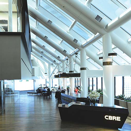 A large room with white pillars and a few people sitting at tables.
