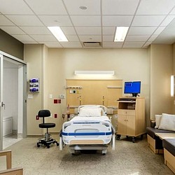 A hospital room with a bed and desk.